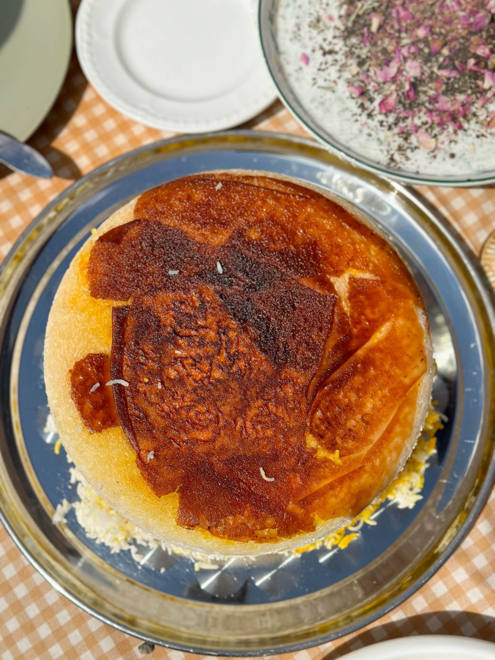 A plate of perfectly golden tahdig, showcasing its crispy rice crust with a beautiful, uniform golden-brown color. ready to serve with Joojeh Kabob.