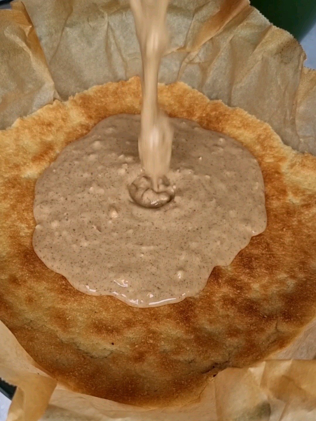 Pour the melted peanut butter on top of baked almond flour mix.