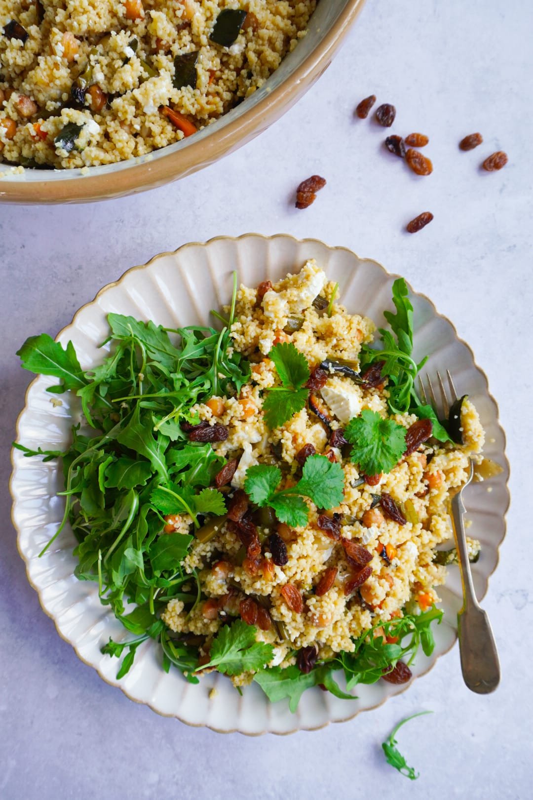 Vibrant green rocket leaves sprinkled on top of the vegetable roasted couscous salad