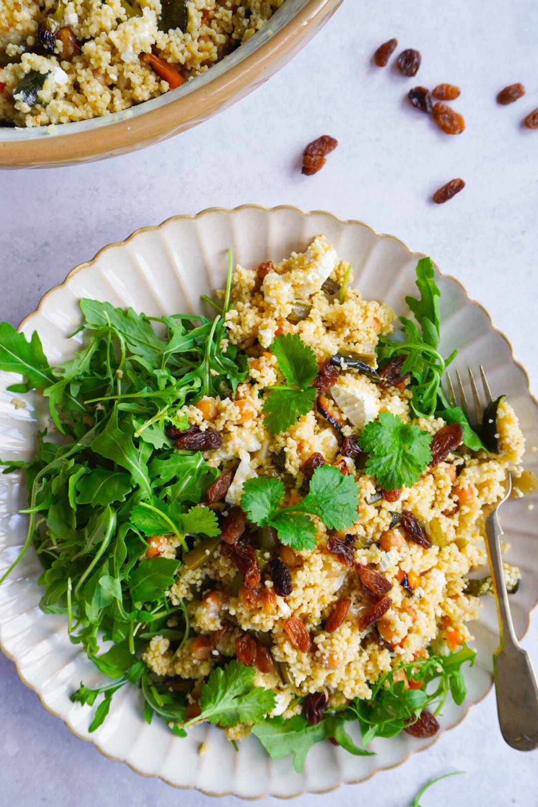 Roasted vegetable couscous salad served with feta cheese, arugula and sultanas