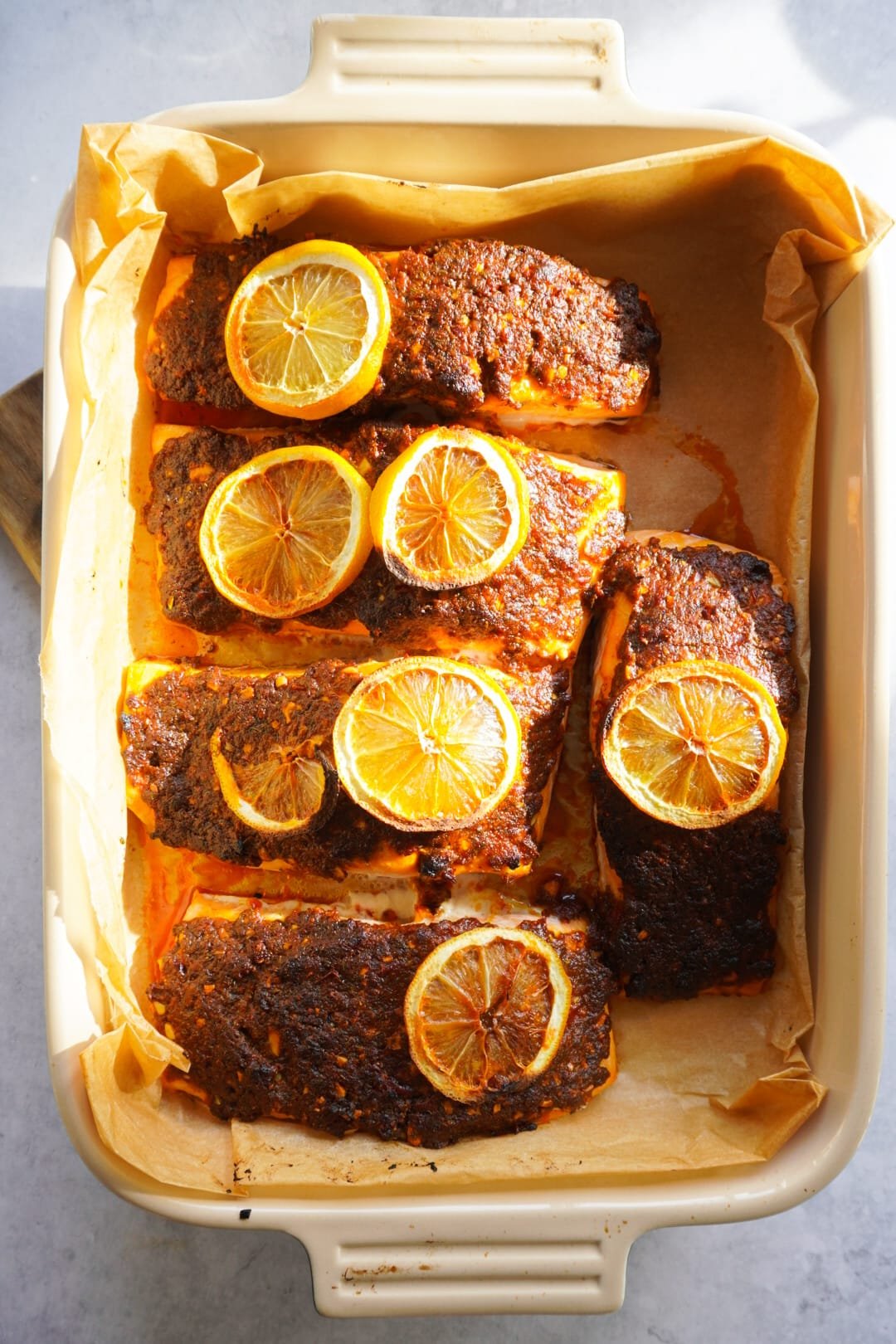 Add sliced lemon on top of the salmon pieces and put the baking tray in a preheated oven to bake for 15 minutes.