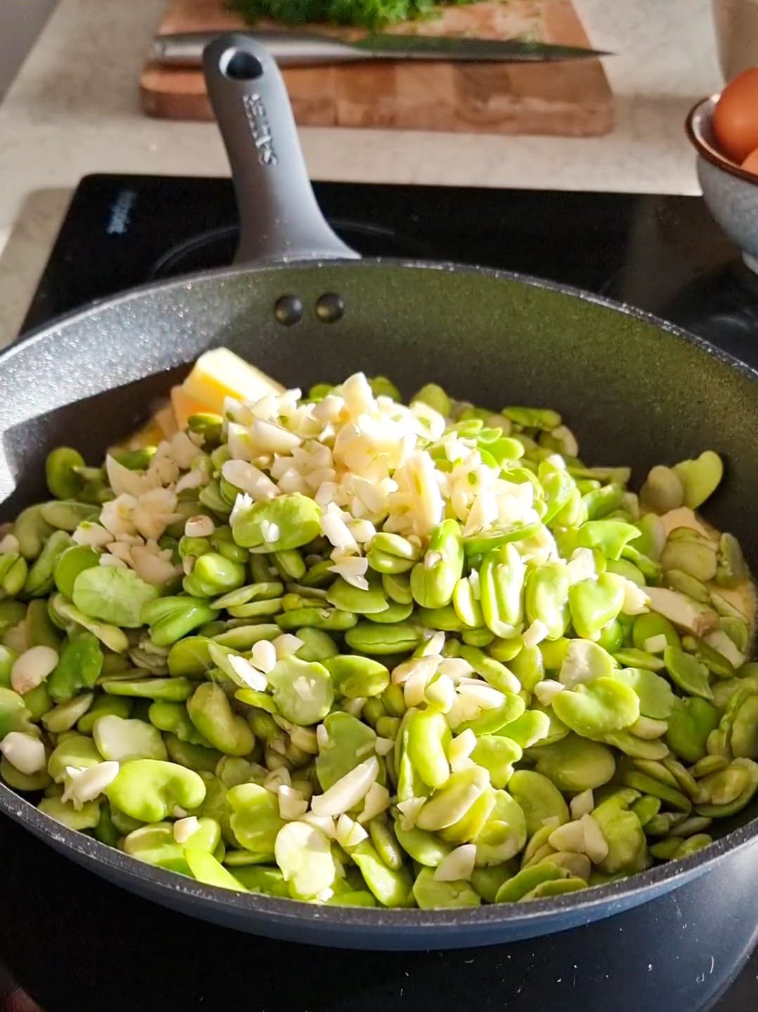 the green fava beans combined with garlic in a pan