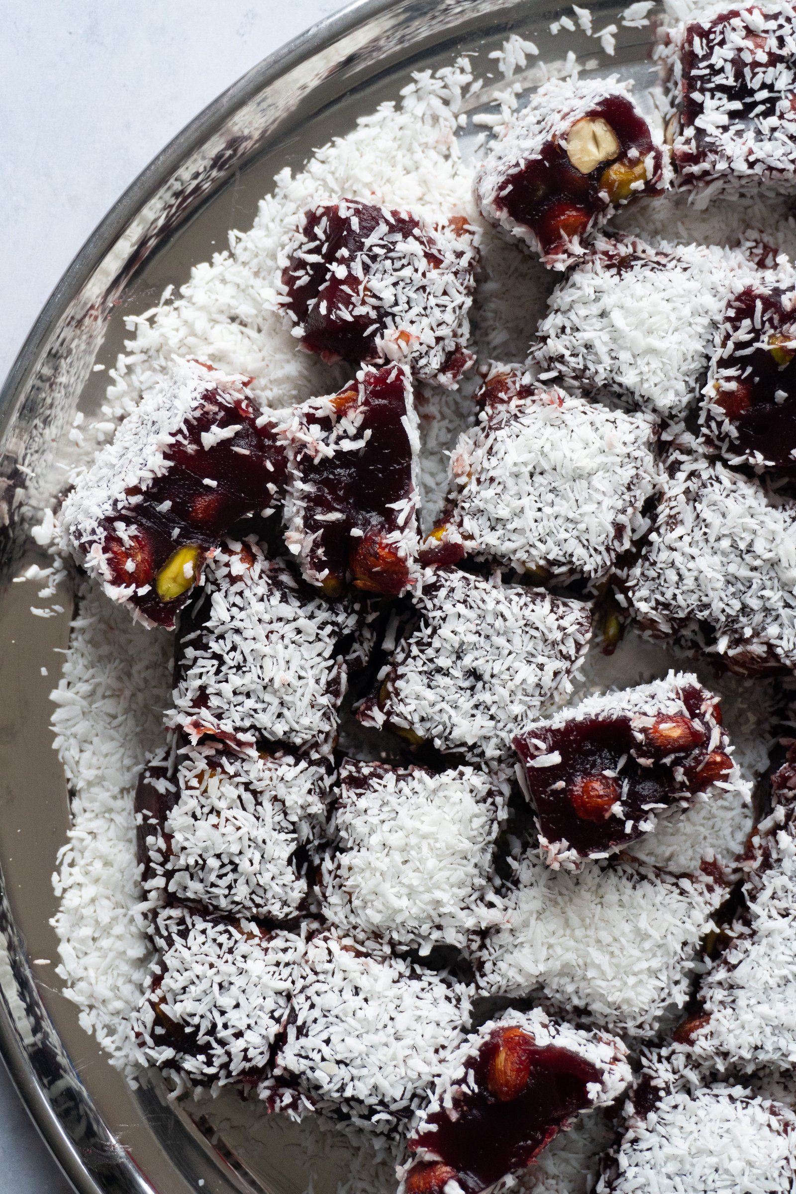 A top down view of a plate of pomegranate Turkish Delight, showcasing the intricate and decorative shapes.