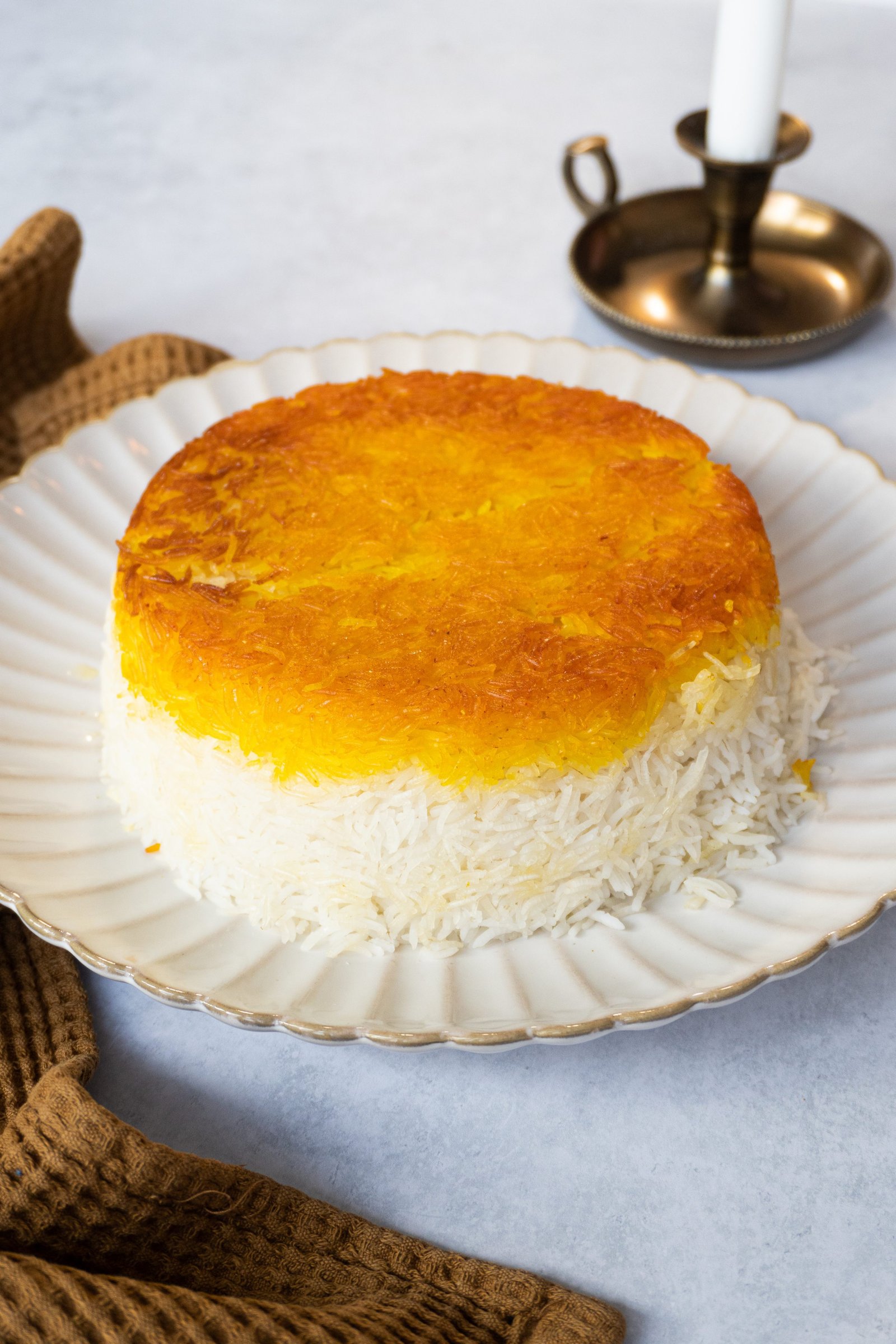 A straight-on image of a persian saffron rice with tahdig, showing the perfectly round shape and vibrant golden color of the dish."
