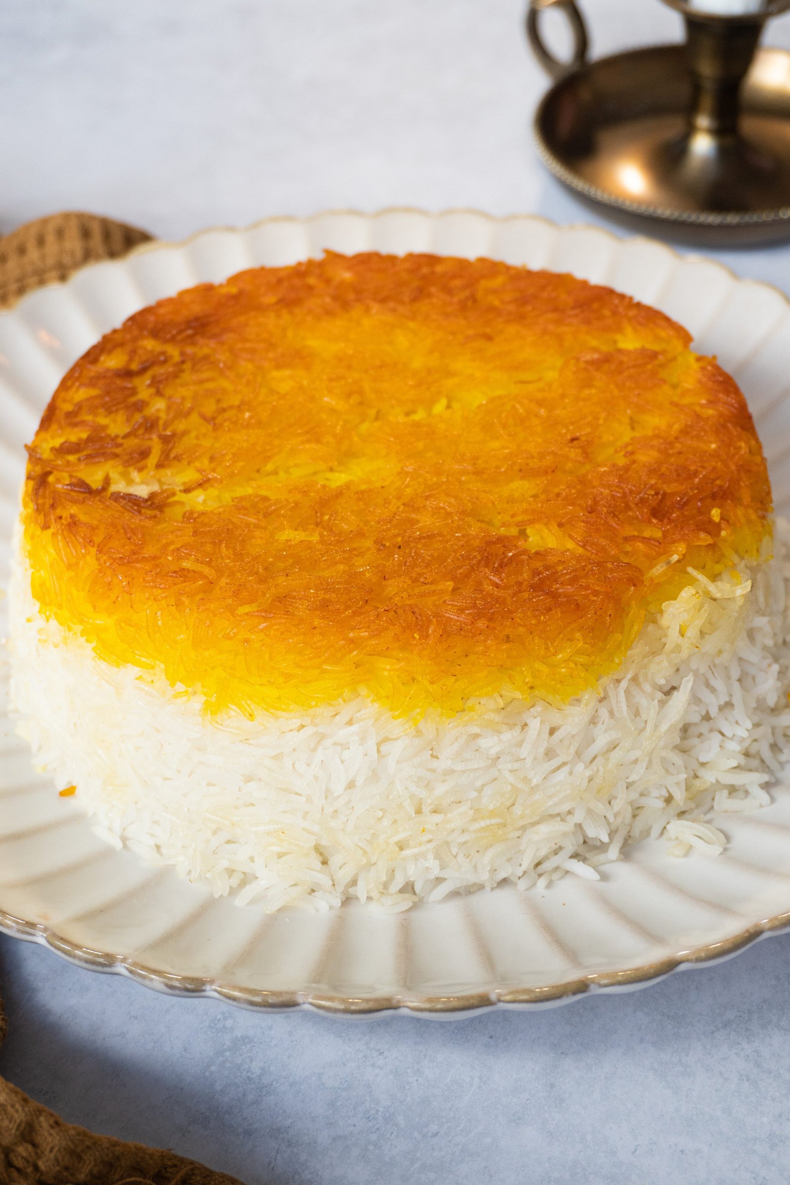 A close up of Persian saffron rice with tahdig showing the perfectly round shape and vibrant golden color of the dish."