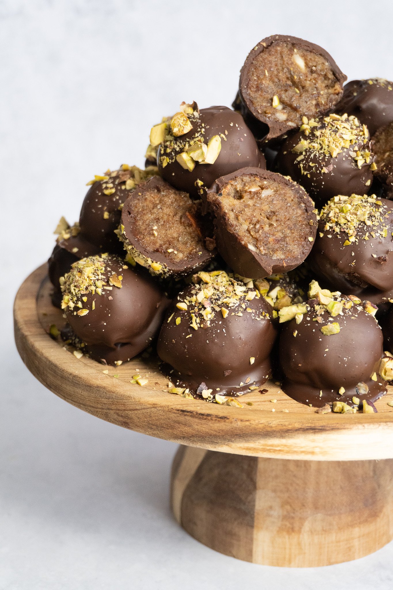 A close-up shot of healthy chocolate date truffle, revealing its chewy date and nut filling.