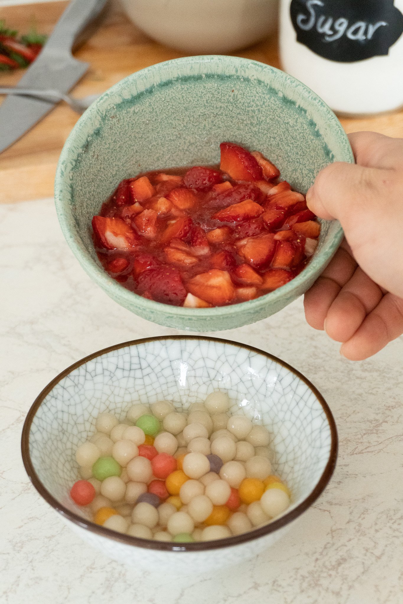 crushed strawberries in a bowl with sugar ready for strawberry milk boba drink 