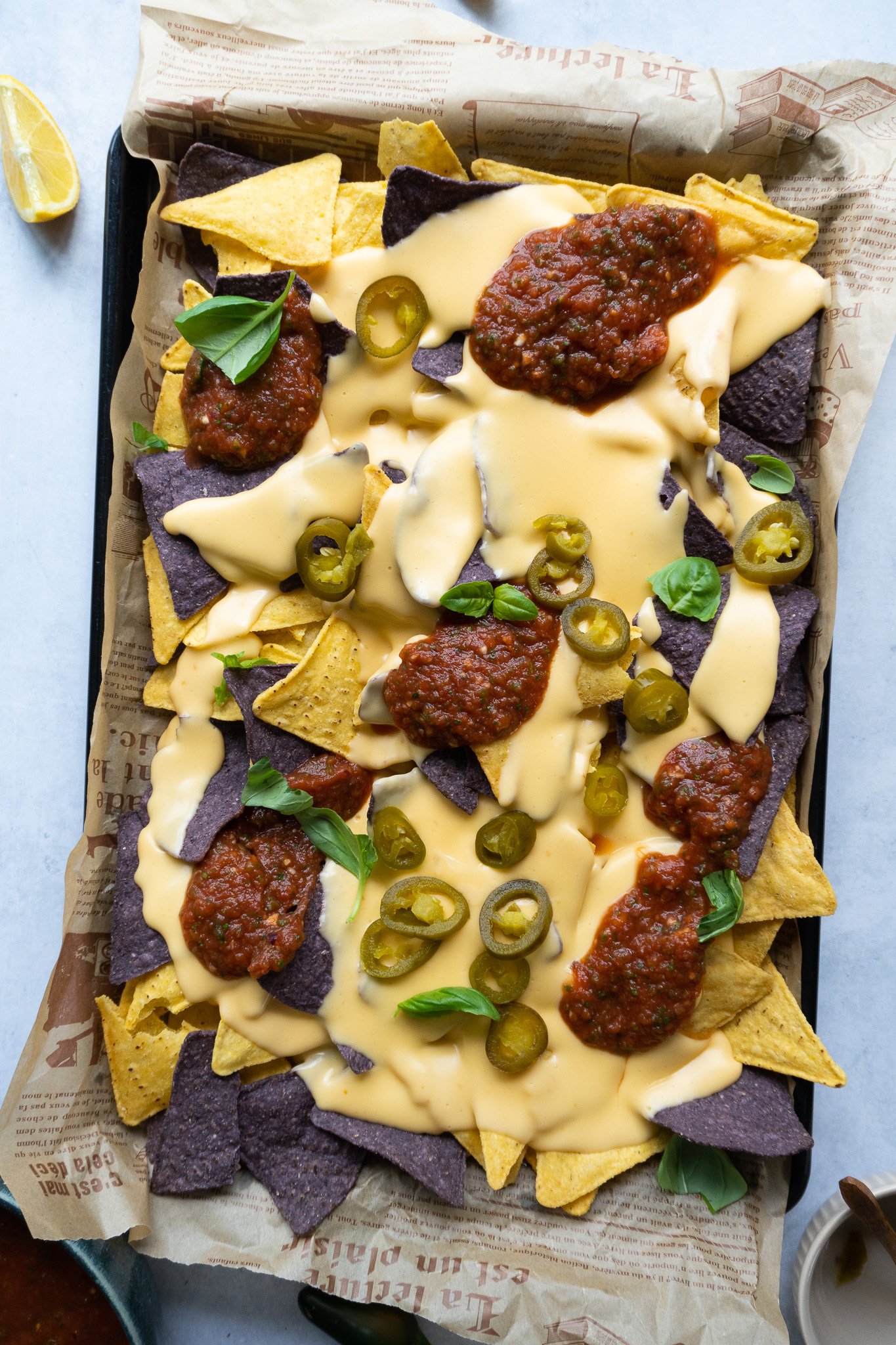 delicious hot tray of homemade nachos with salsa and cheese sauce 
