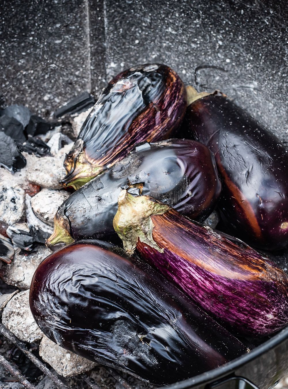 Perfectly charred aubergines on a BBQ ready to be peeled and turned into, Smoky Creamy Mutabal with Tahini 