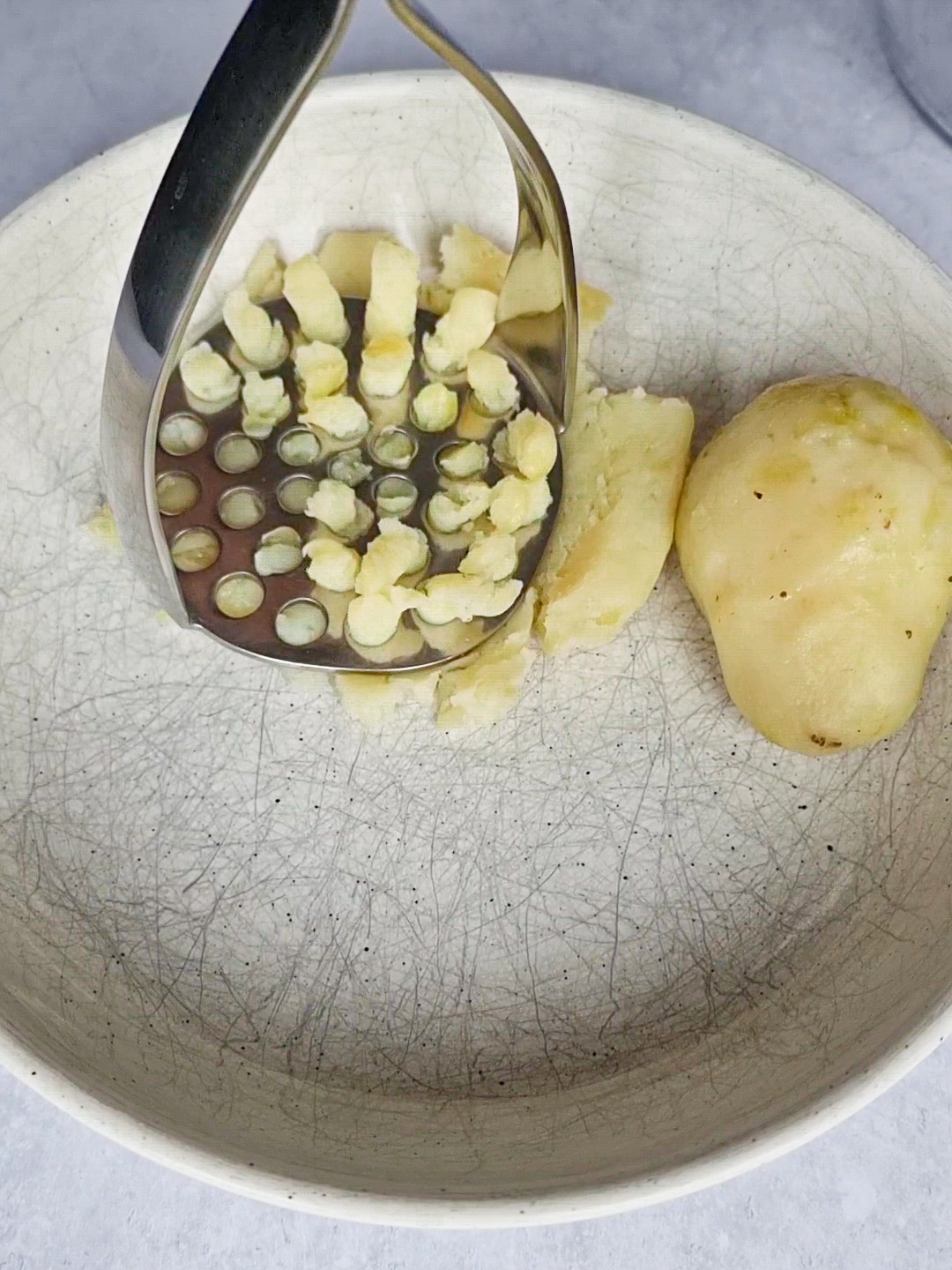 Mashing potatoes to  be seasoned and fried to make delicious Kuku sibzamini