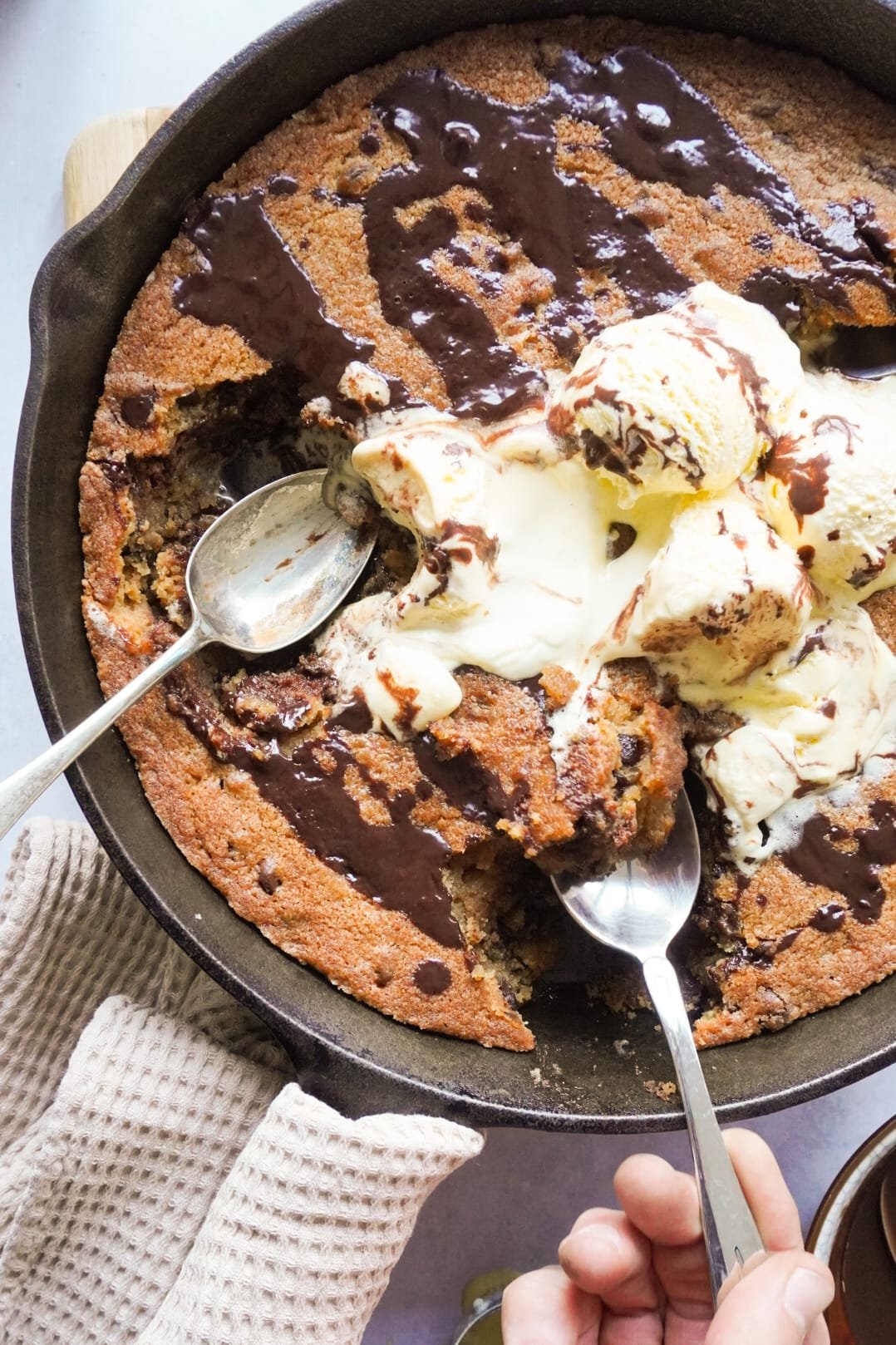 Pan chocolate chip cookie drizzled with chocolate sauce and a scoop of ice cream