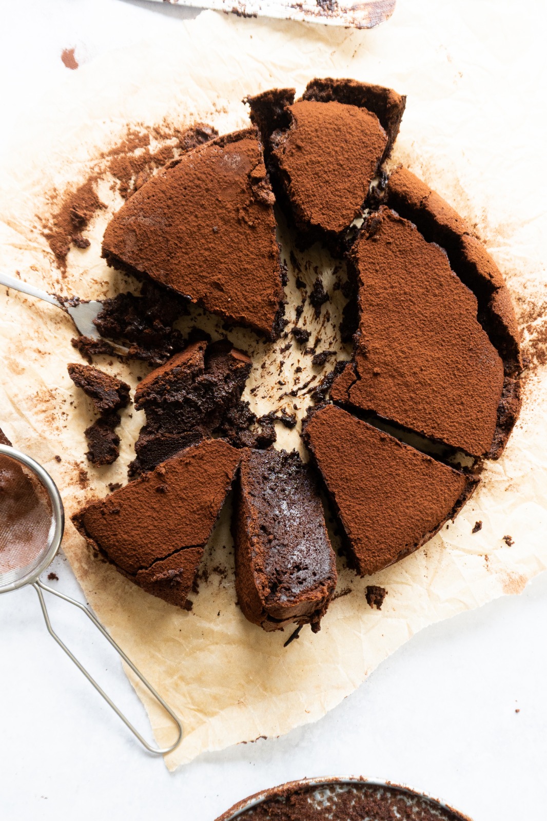 Sprinkle more cocoa powder to finish off your Flourless Chocolate Cake.