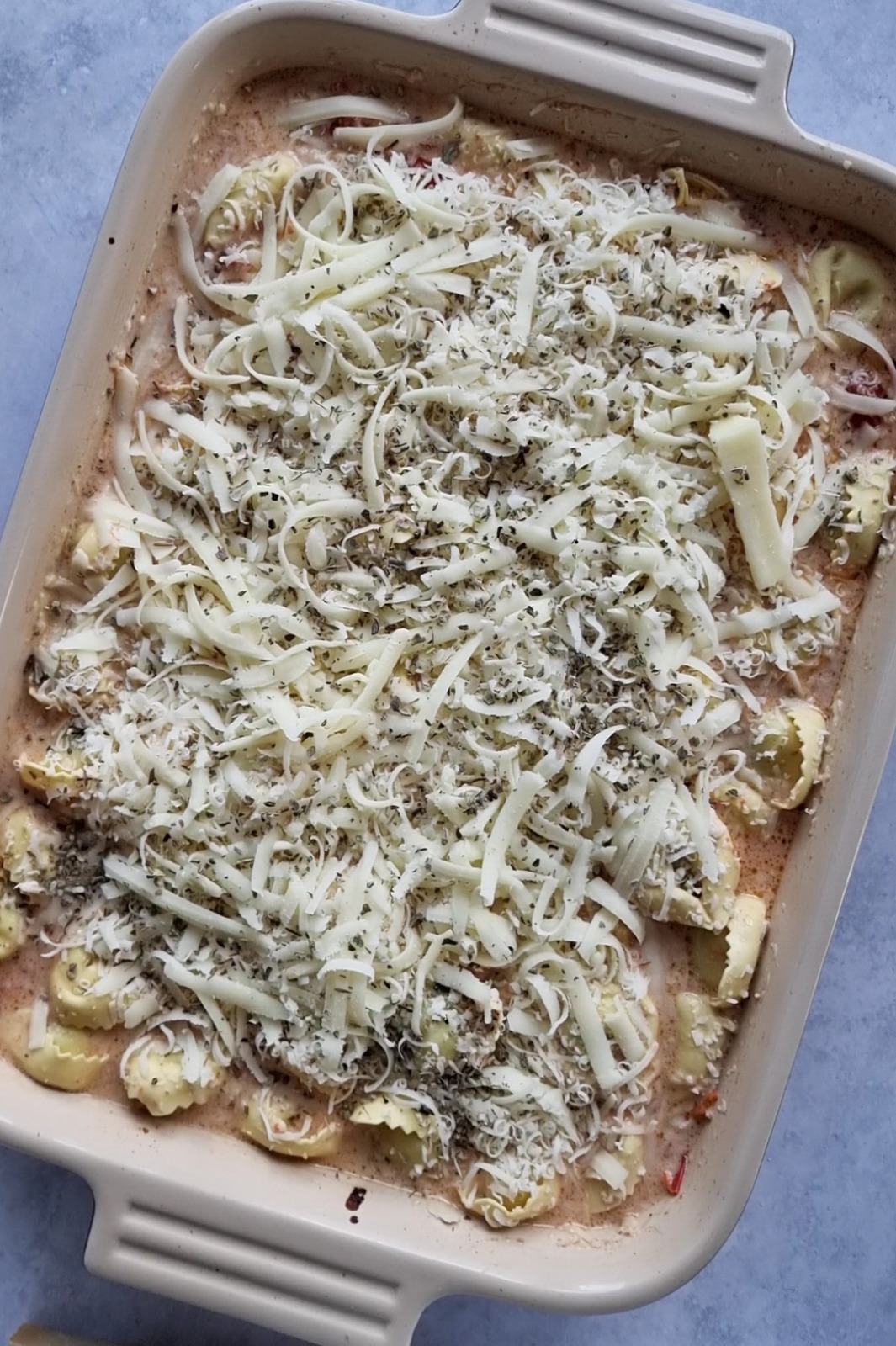 Creamy Tomato Garlic Tortellini Bake topped with parmesan and mozzarella cheese. 