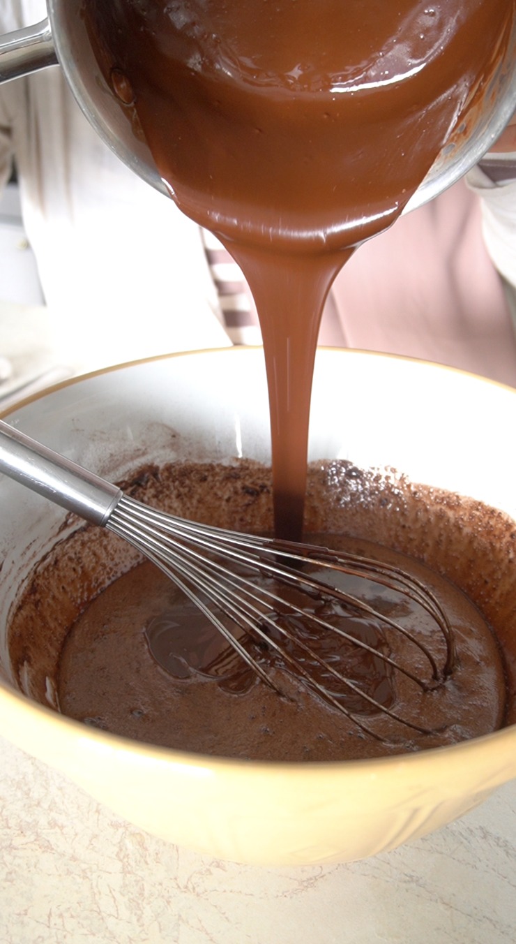 Add the cooled melted chocolate and butter mixture to the whisked bowl and mix again until well combined.