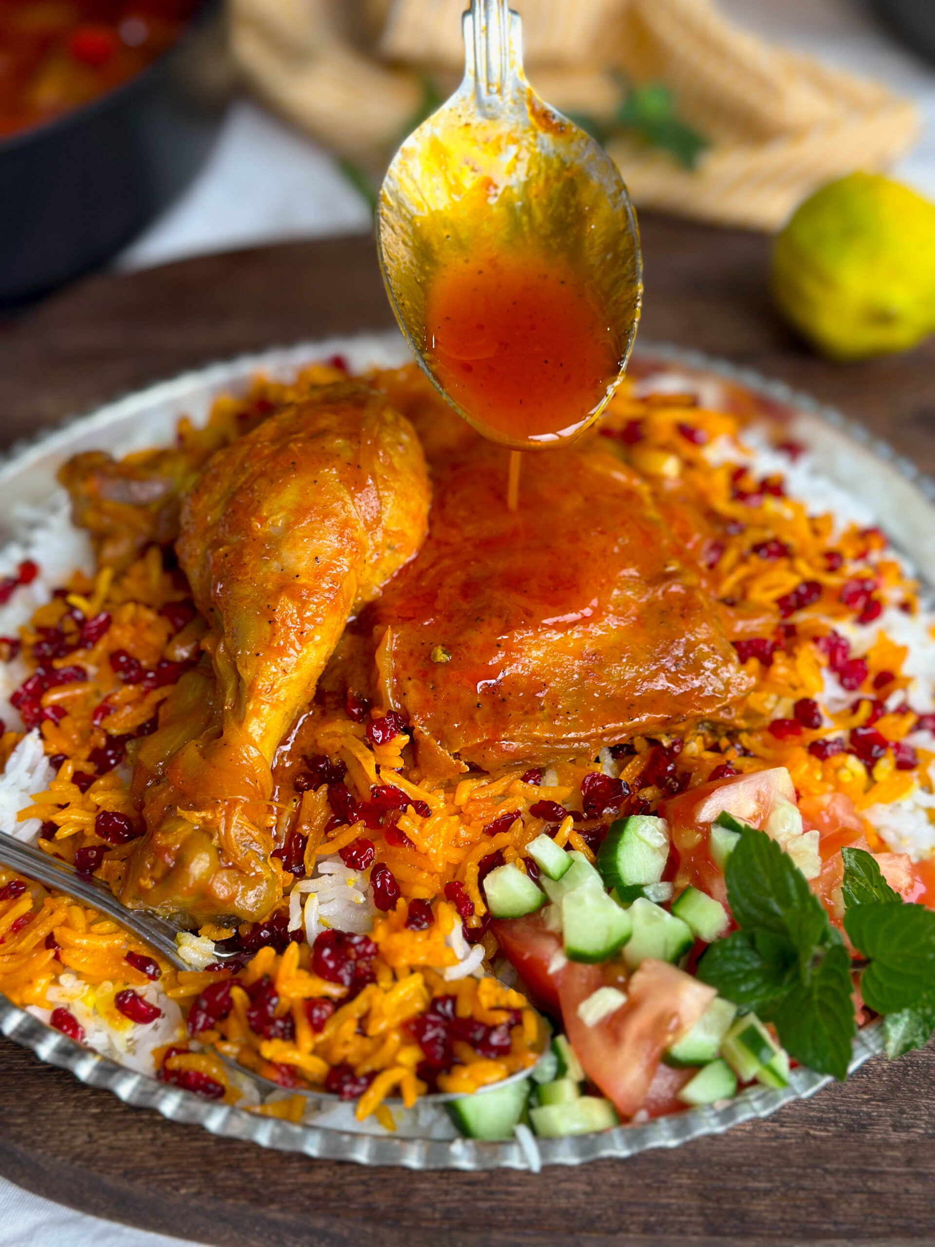 A beautifully arranged plate of Zereshk Polo Morgh, showcasing the tender chicken, fluffy rice, and bright red barberries.