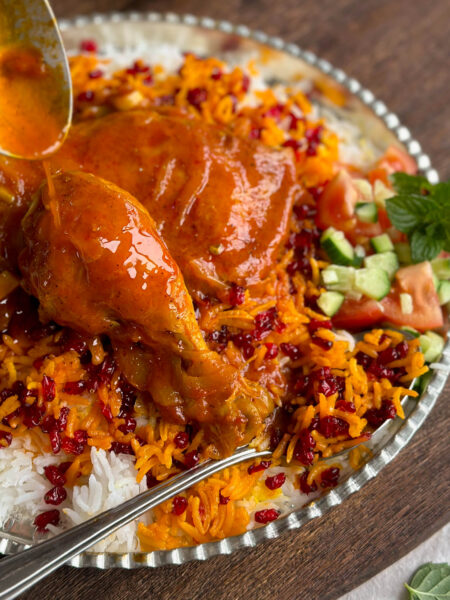 A close-up of a serving of Zereshk Polo Morgh, showing the rich colors and flavors of this classic Persian dish.