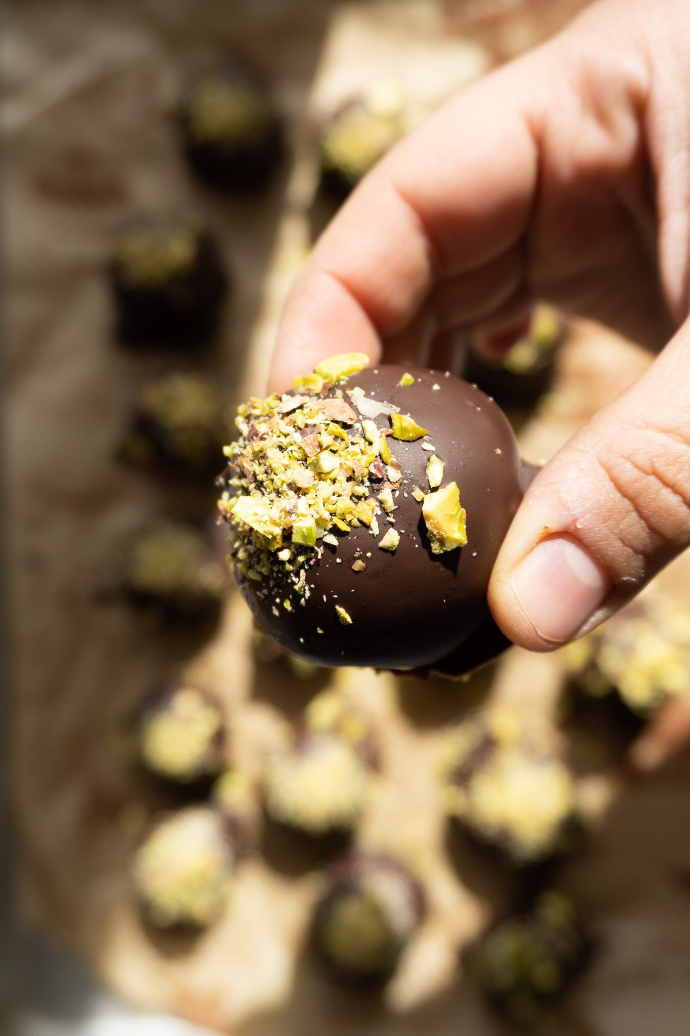 an easy truffle recipe that is easy and delicious. Image of a whole chocolate date truffle close up. 