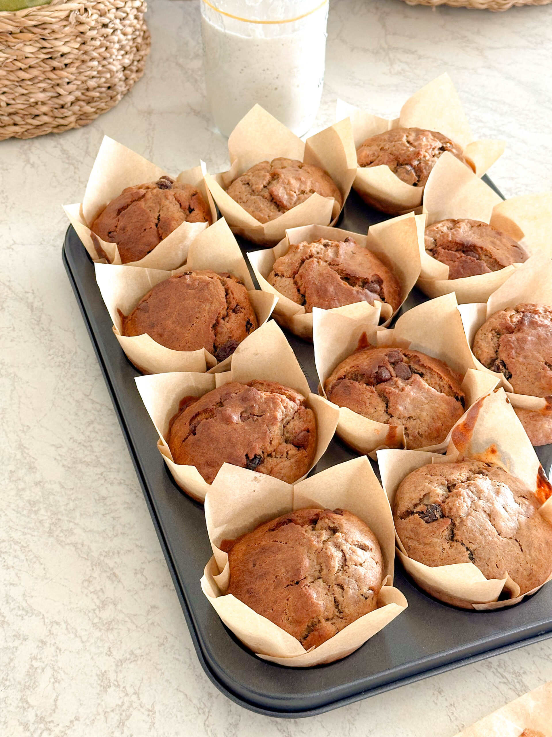 Sourdough banana bread muffins neatly cooling in a muffin try.