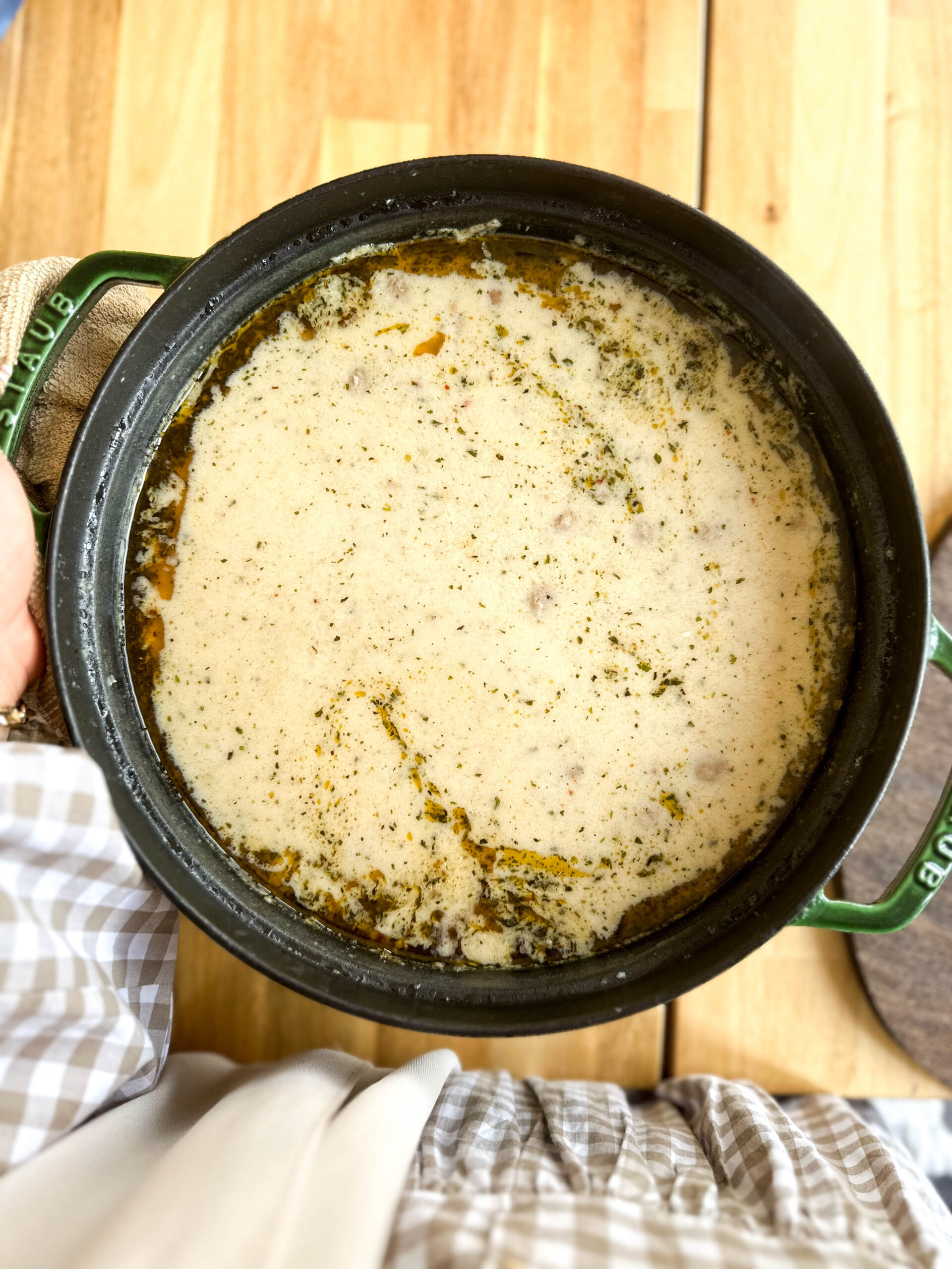 Top-down view of a pot of Lebeniye Soup – The Best Turkish Meatball and Yoghurt Soup, with butter, mint, and pul biber drizzle.