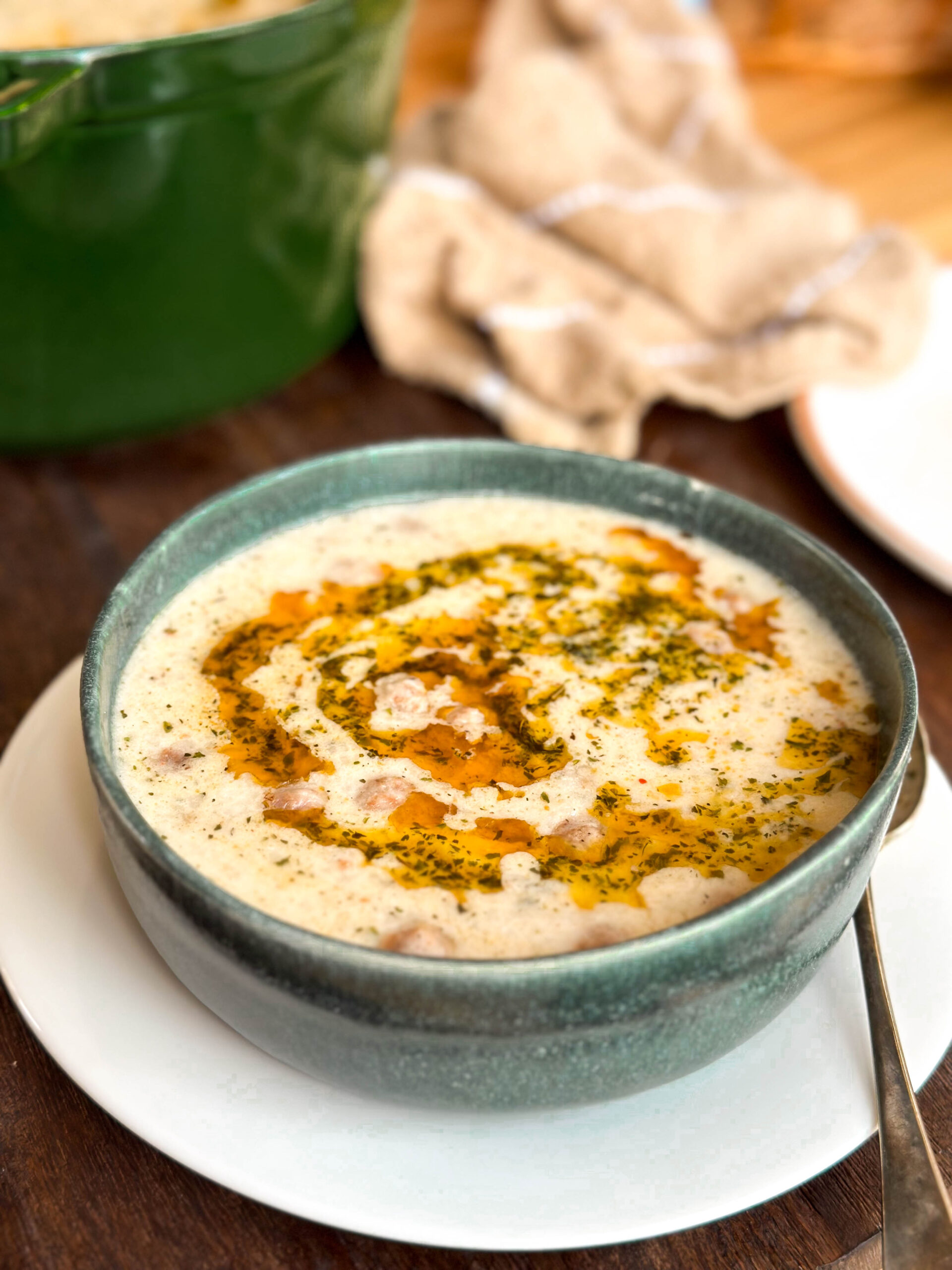 Side view of Lebeniye Soup – The Best Turkish Meatball and Yoghurt Soup, showing creamy broth, golden meatballs, and chickpeas.