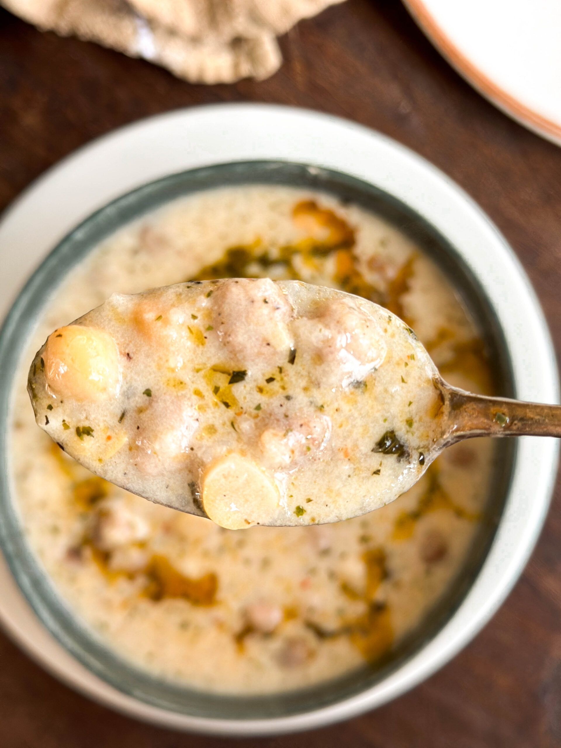 Spoonful of Lebeniye Soup – The Best Turkish Meatball and Yoghurt Soup, showing meatballs, chickpeas, and creamy broth.