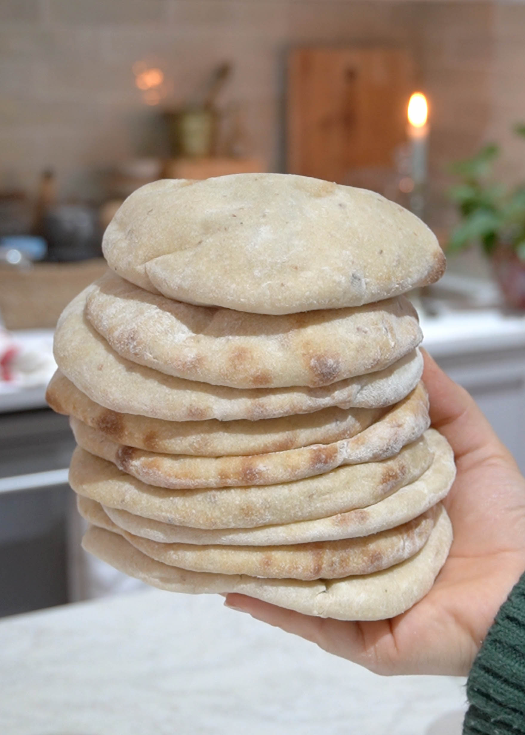 A stack of freshly baked Super Easy Sourdough Pita Bread, soft, fluffy, and slightly golden, ready to be served.