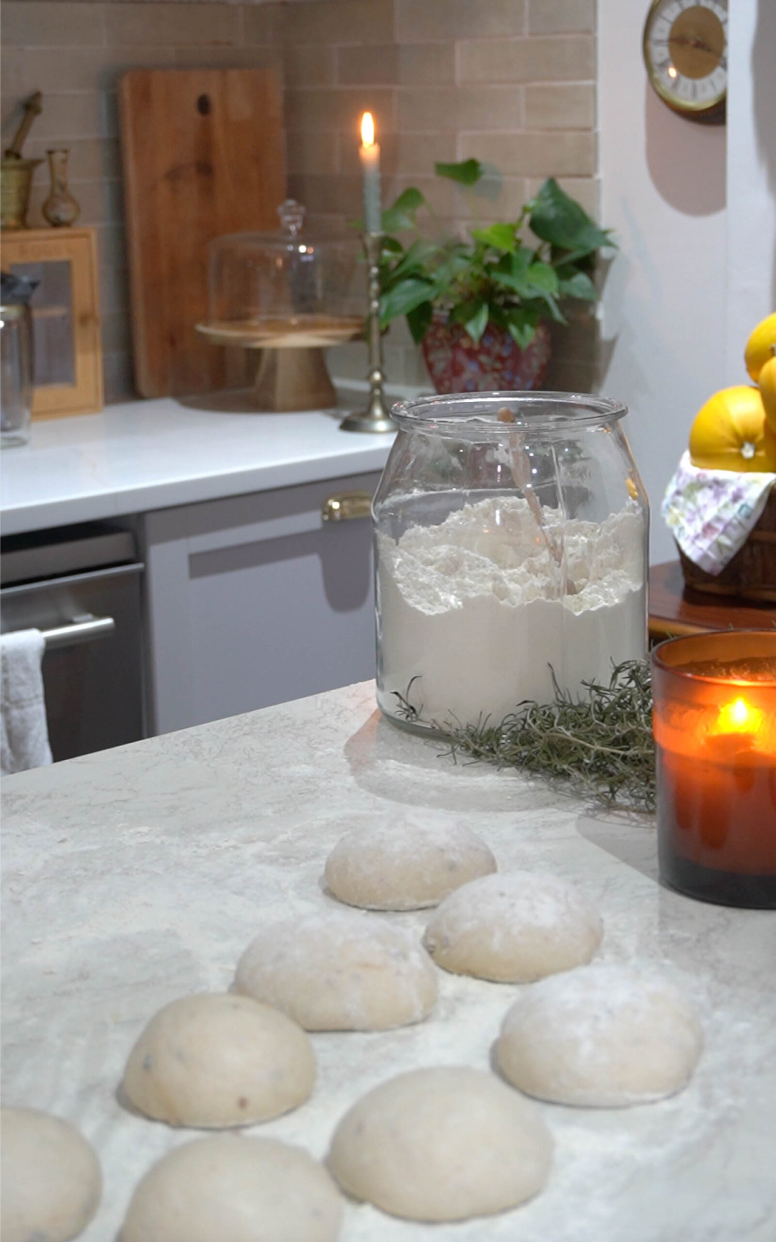 Portioned super easy sourdough pita bread dough balls resting on a floured countertop, proofing before baking.