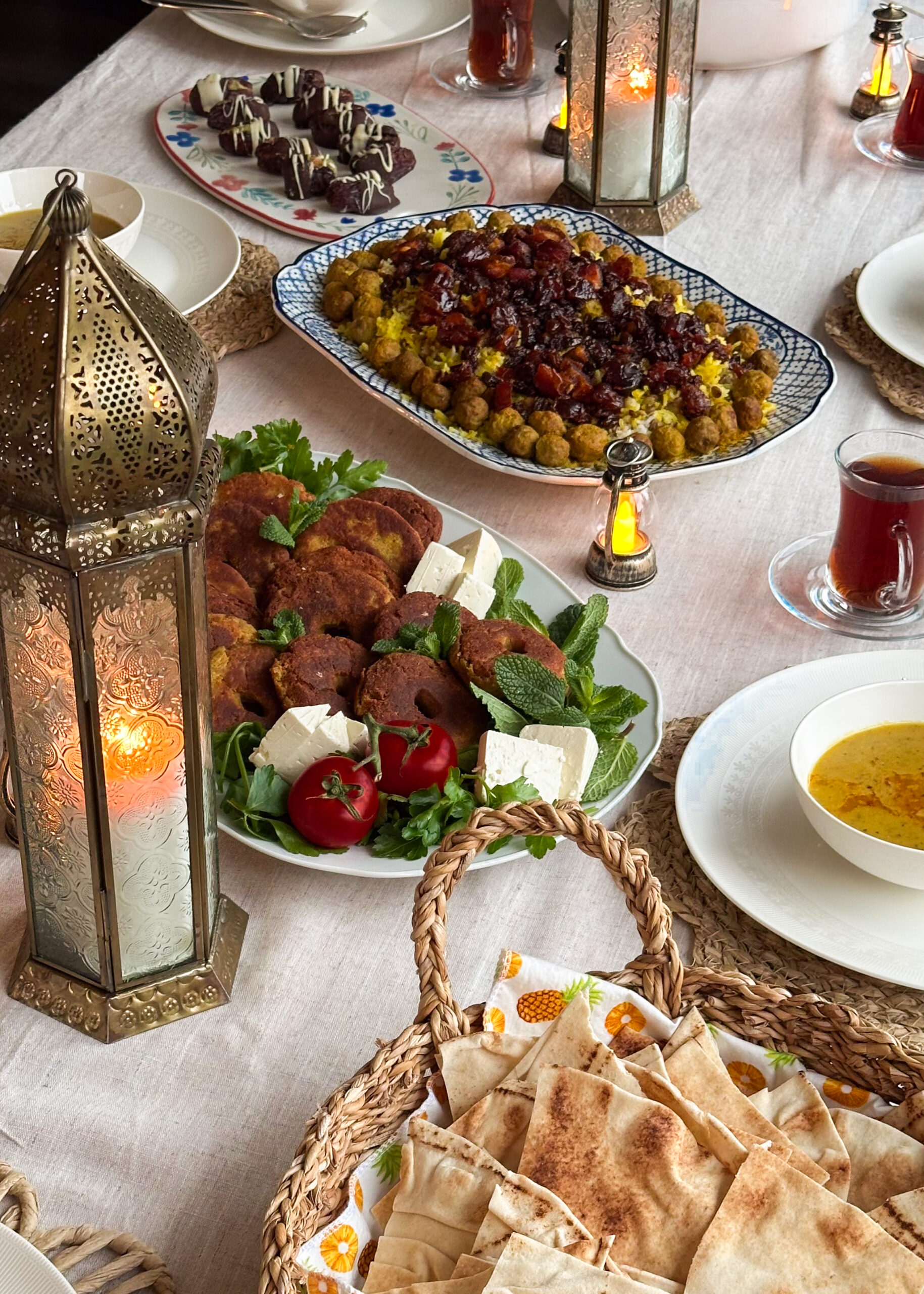 Family-style table setting with Adas Polo as the centrepiece, surrounded by side dishes and drinks.